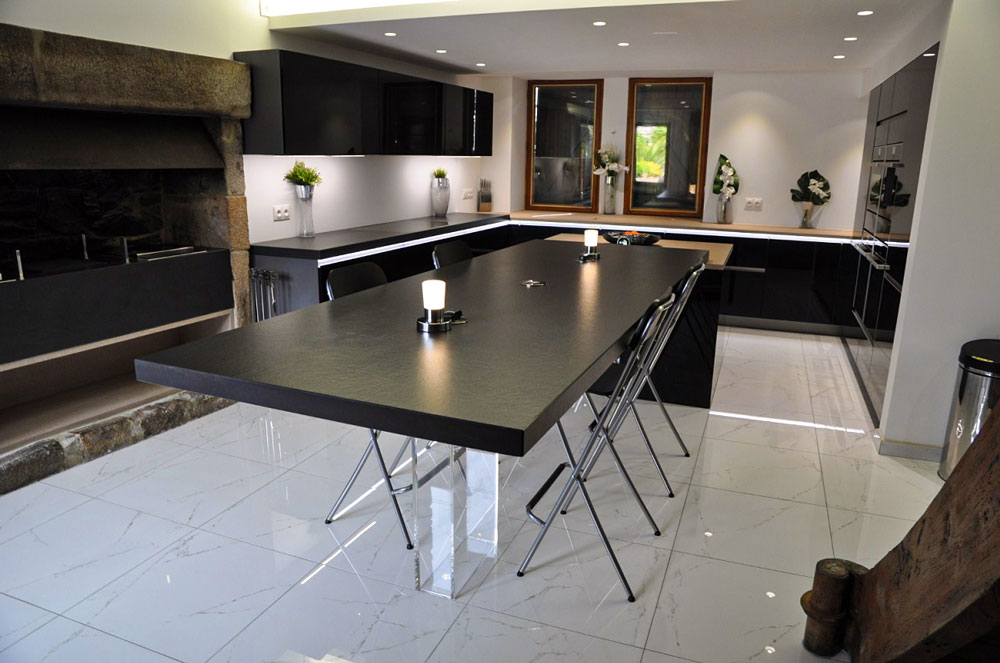 Très jolie laque noire dans cette cuisine ou le pird en verre de la table rend un côté léger et aérien